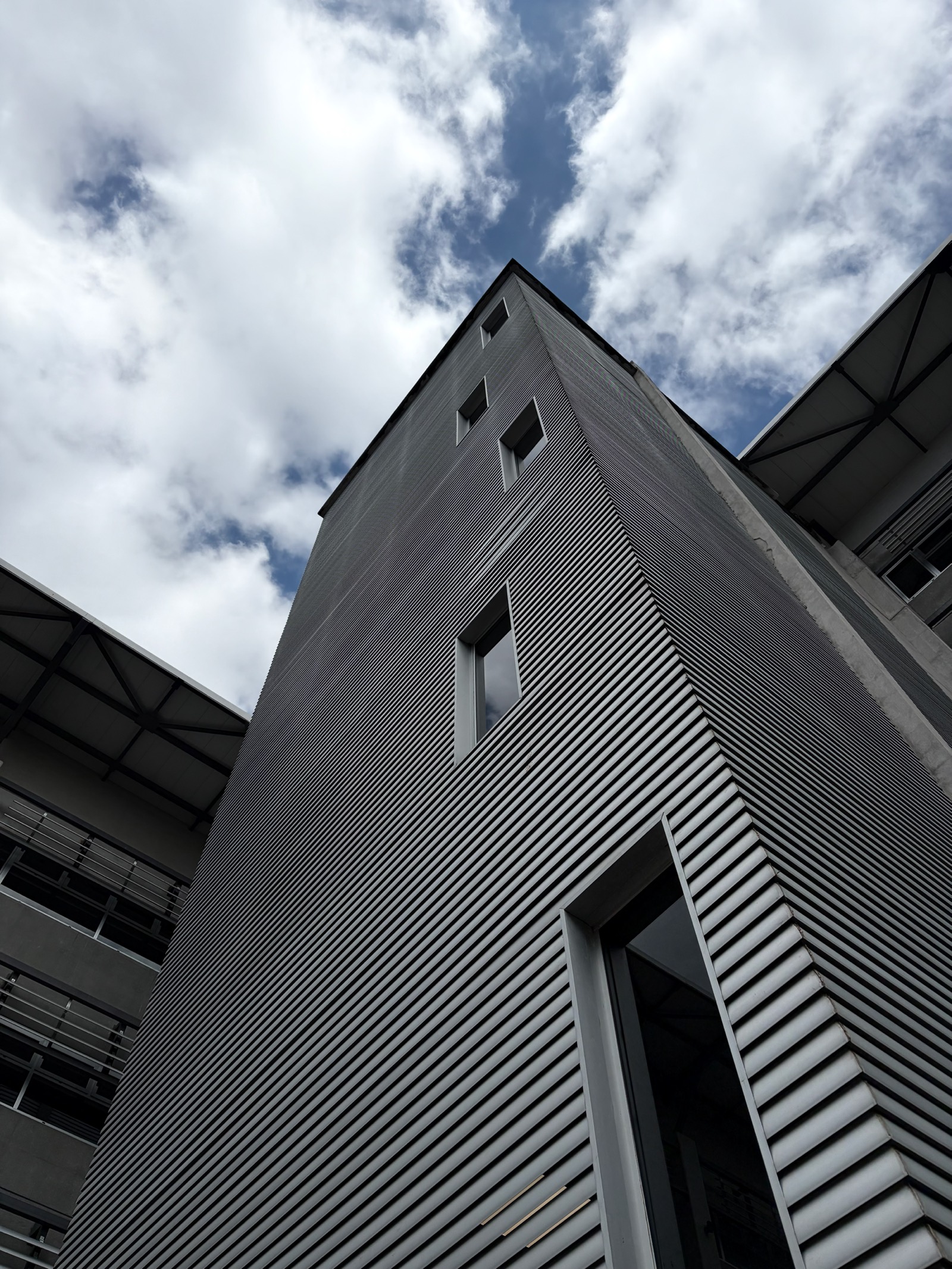 Fachada de un edificio vista desde abajo, entre nubes.